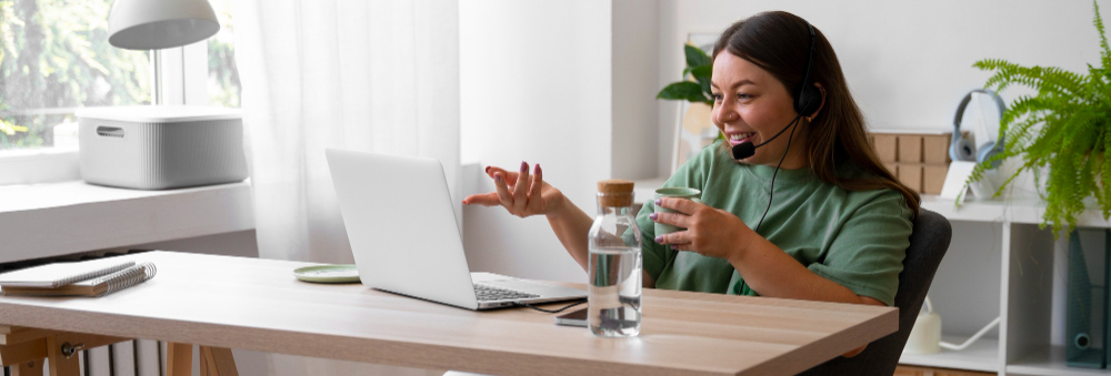 A woman is seen talking to team members on a virtual call from her home office.